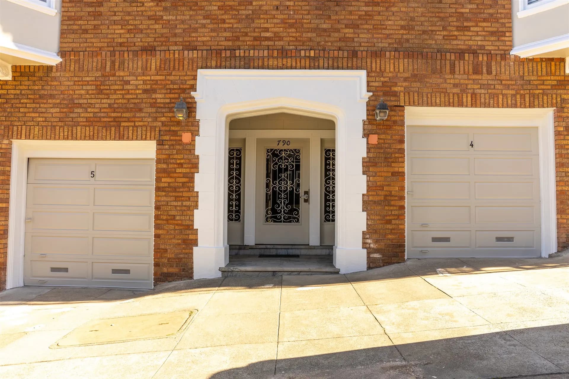 White entry surround and two white garage doors on the brick apartment building in San Francisco