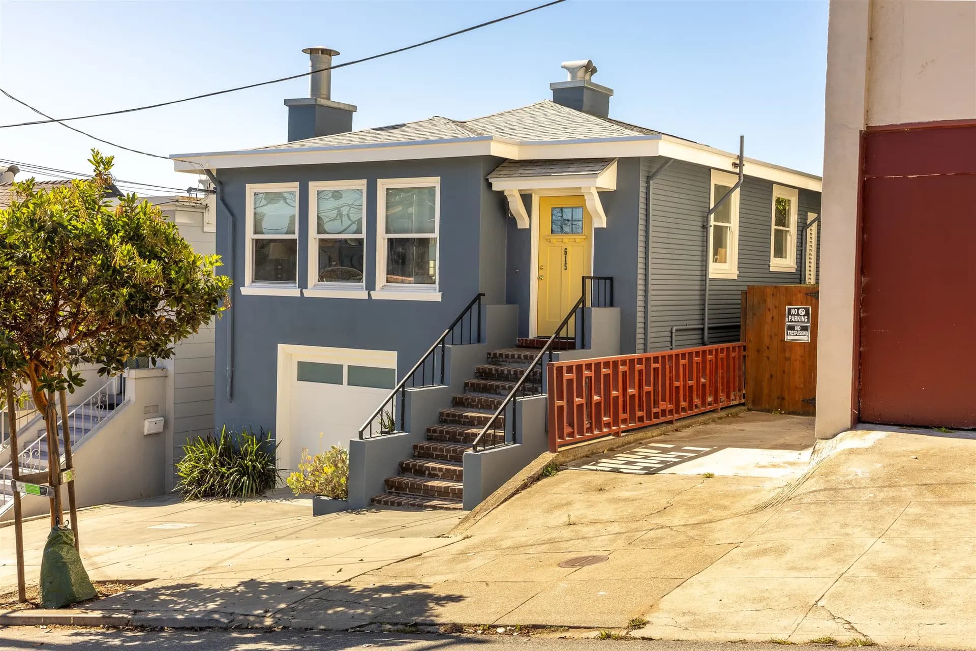 Another angle of the same San Francisco house exterior with white trim, a yellow door, and the stair