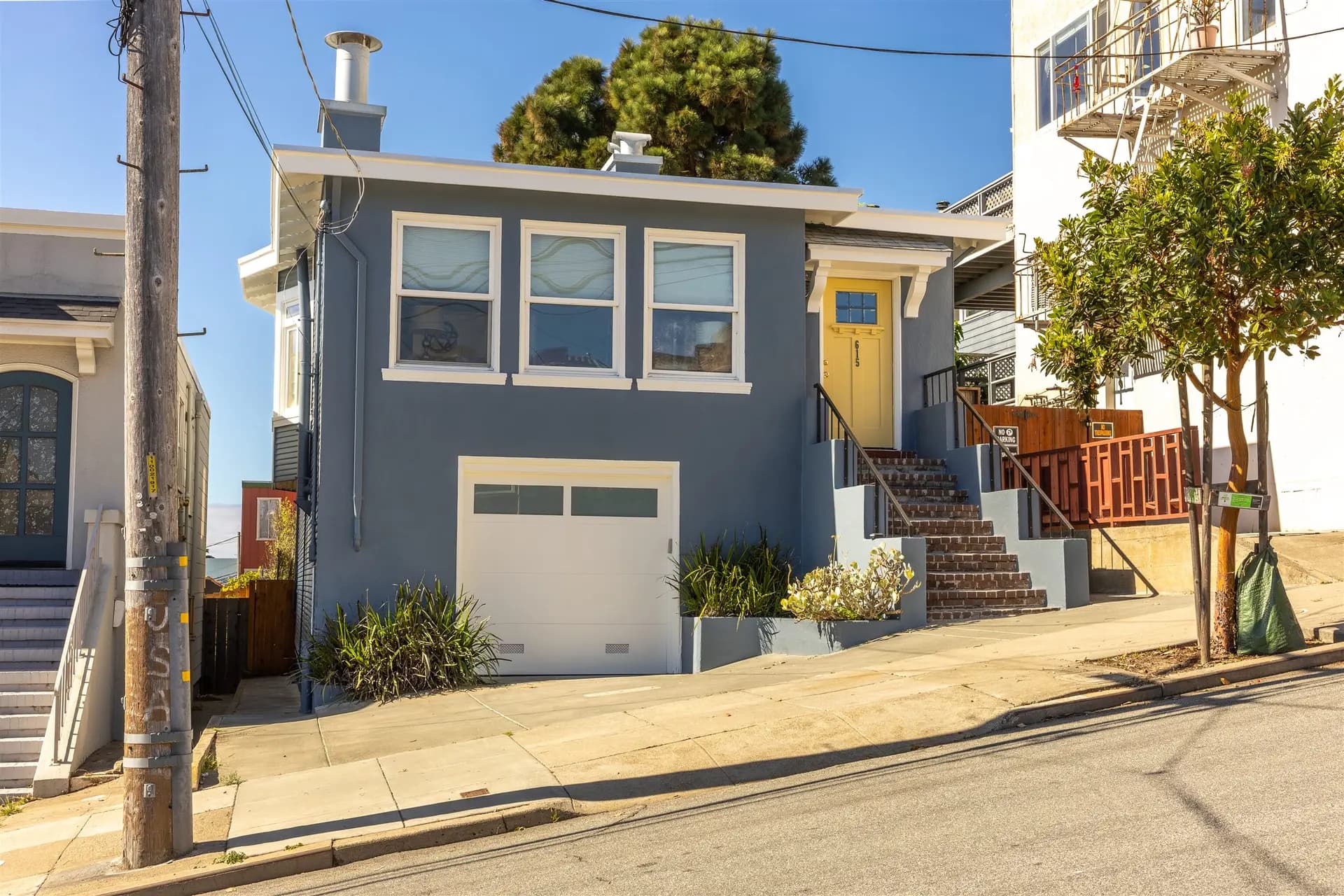 Exterior repaint of a single-family home in San Francisco with white trim and a white garage door by Pasion Painting
